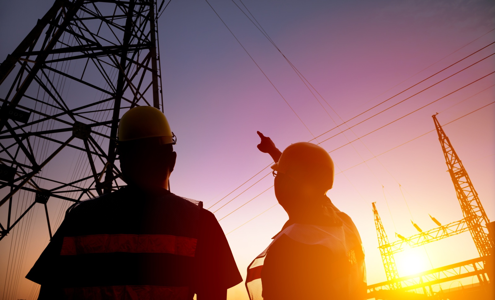 2 workers looking at power station