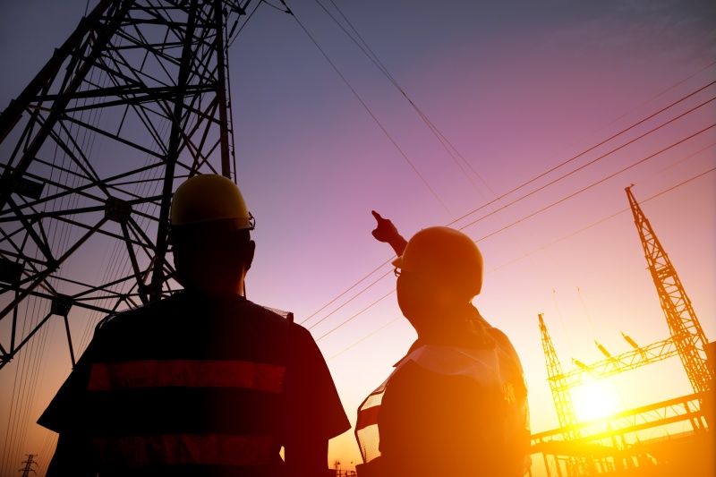 2 workers looking at power station